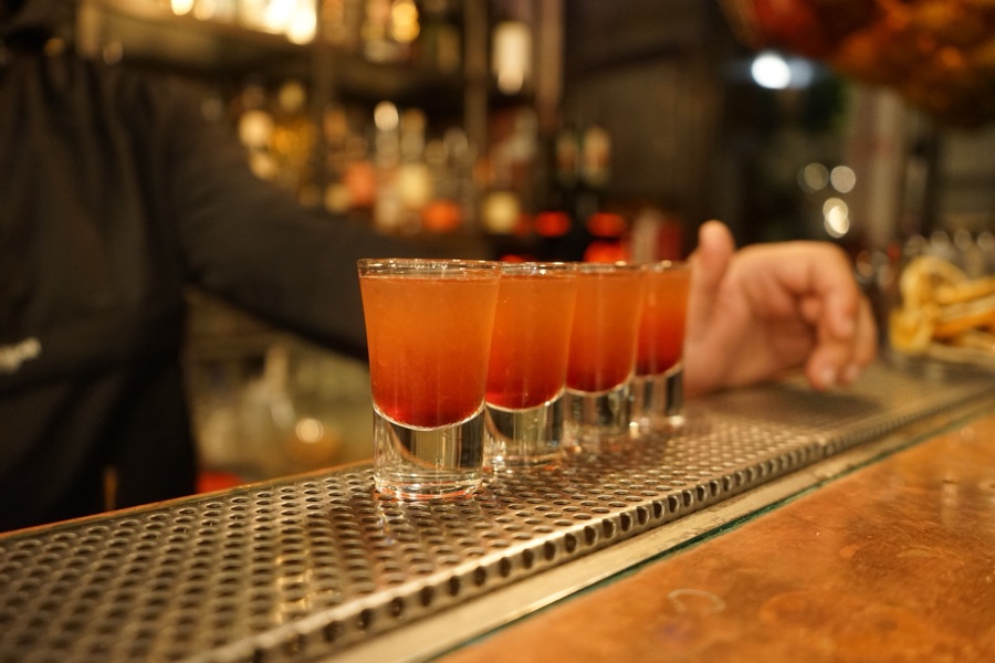 A row of layered shot drinks lined up on a bar